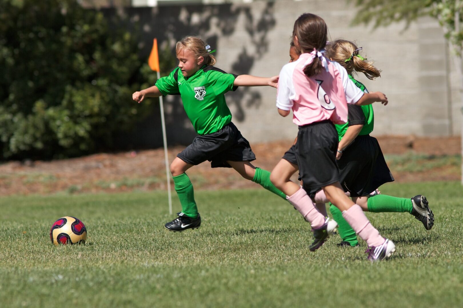 A group of young girls playing soccer on the field.